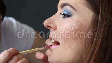 化妆师将唇彩涂于模特唇上，全高清